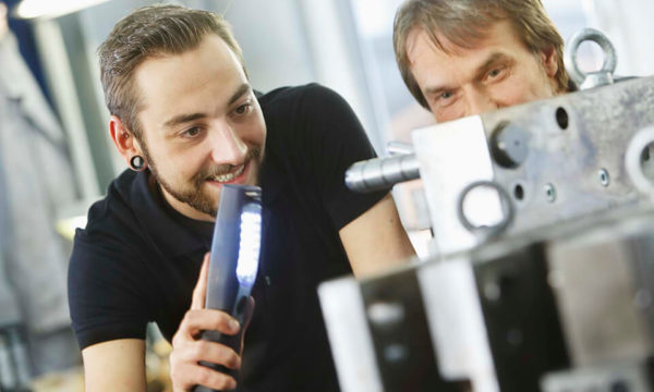 Mitarbeiter schauen auf Spritzgusswerkzeug