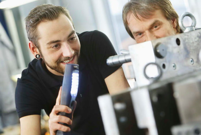 Mitarbeiter schauen auf Spritzgusswerkzeug